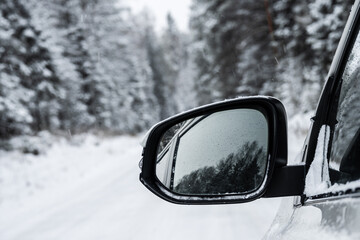 Natural background. A car in a winter forest while driving on a snowy road.