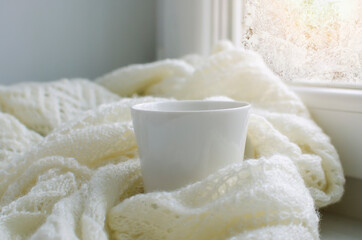 Cup of tea on White knitted plaid.