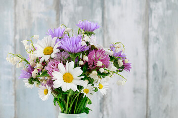 Cute bouquet of daisies, carnations, chamomile and lily of the valley flowers.