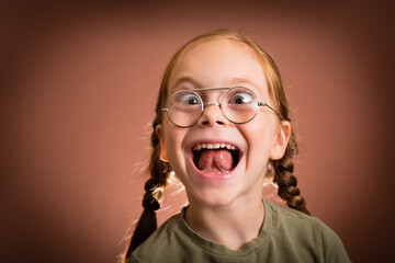Excited Young Girl with Thick Eyeglasses, Making a Funny Face - obrazy, fototapety, plakaty
