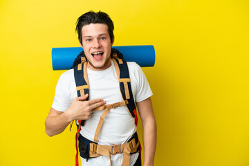 Young mountaineer Russian man with a big backpack isolated on yellow background with surprise facial expression