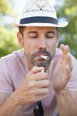 a middle aged man smokes outdoors
