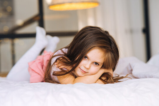 Little girl lying in the bed looking away.