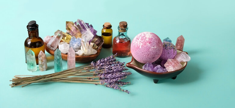 Gemstones minerals, lavender, Spa treatments - essential oil bottles, bath bomb, lavender on green-blue background. Crystal ritual, spiritual practice, body care. Wiccan Witchcraft. copy space