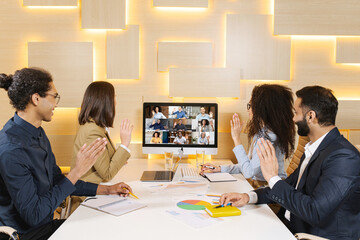 Multi ethnic group of business people having discussion with another colleagues via video call in office, need everyone to give the best ideas, putting plans into motion, finding solutions together