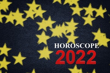 Word Horoscope 2022. Blocks with letters on dark background decorated with starry confetti.
