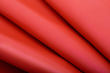 Dyed coral folded natural cow leather on the wooden table	
