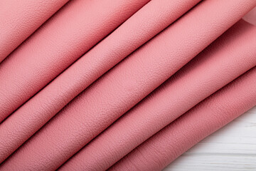 Pink folded natural cow leather on the wooden table	
