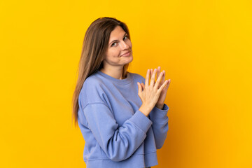 Young Slovak woman isolated on yellow background scheming something