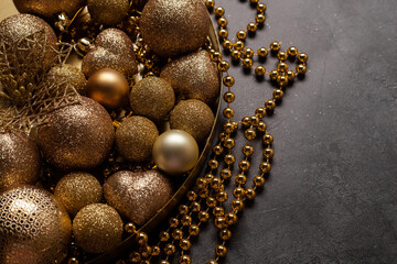 Black background with golden Christmas balls and with copy-space. Suitable for invitations, greeting cards, postcards