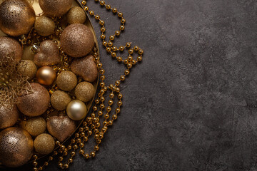 Black background with golden Christmas balls and with copy-space