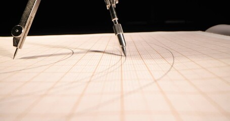 Macro of the compass drawing a circle on paper. Close up, side-view camera tracking. 4k