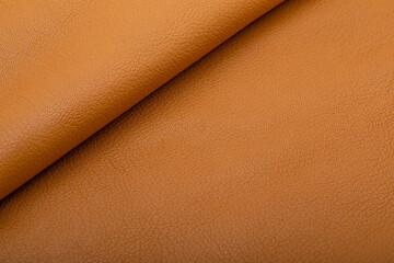 Fototapeta premium Sand brown colored folded natural leather on the wooden table