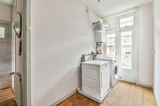 Washing machine against white wall near door