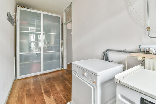 Washing machine against white wall near door