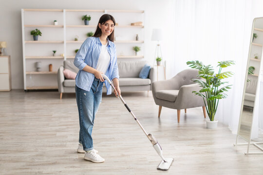 Portrait Of Cheerful Woman Cleaning Floor With Spray Mop