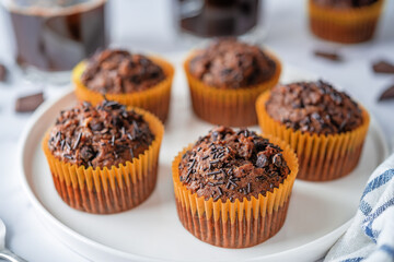 Chocolate muffins with chocolate sprinkles and glasses of coffee