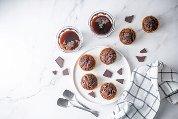 Chocolate muffins with chocolate sprinkles and glasses of coffee