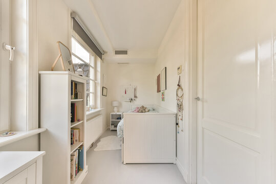 Cozy bed in light bedroom with white furniture