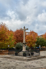 Famous sculpture of the Christ of Favors among autumnal trees in the Realejo neighborhood of Granada (Spain)