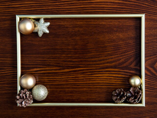 Photo frame, gold decorations on a wooden background. Christmas, winter, new year concept. Flat lay, top view, copy space.