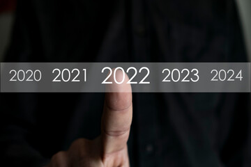 Unknown hand pressing 2021 number on virtual screen, Man finds 2022 year in virtual archive, collection of statistics, annual reports