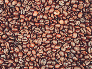 Roasted coffee beans background under electric light overhead view.