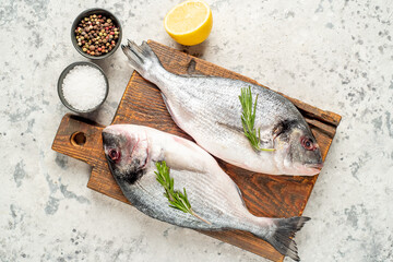 raw dorado fish on a light stone background