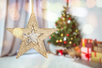 Fototapeta na wymiar Christmas star on background of christmas lights in evening room.