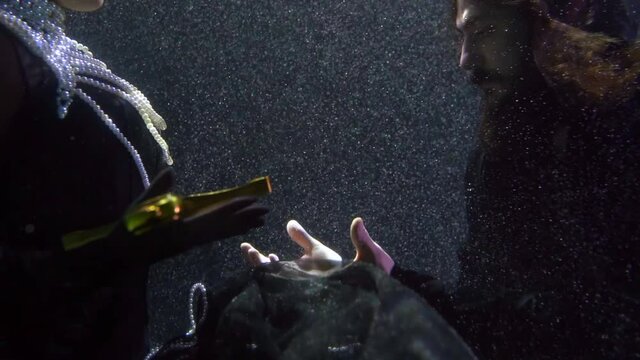 medieval queen is giving sword to knight, closeup shot inside water, underwater shot