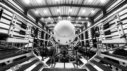 Space launch preparation. Spaceship SpaceX Crew Dragon, atop the Falcon 9 rocket, inside the hangar...