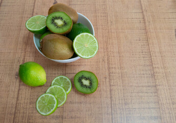 Bowl with green fruit. Citrus limon and Actinidia deliciosa.