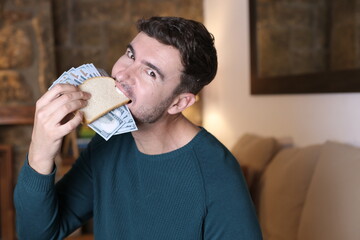 Man enjoying sanwich filled with dollars