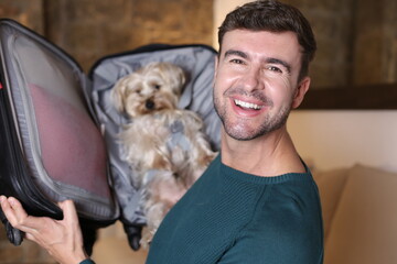 Man packing his cute dog in suitcase