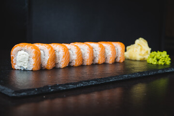Set of sushi rolls with wasabi and ginger on a black background. Japanese oriental cuisine