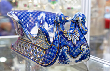Porcelain sleigh with swans in the Russian Gzhel style. Traditional russian souvenir.