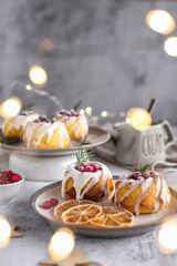 lemon cupcakes decorated with cranberries and icing on a light gray background. christmas lemon cupcakes.
