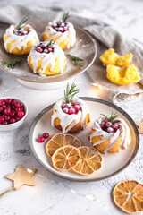 lemon cupcakes decorated with cranberries and icing on a light gray background. christmas lemon cupcakes.
