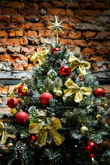 Fototapeta na wymiar Christmas tree near brick wall