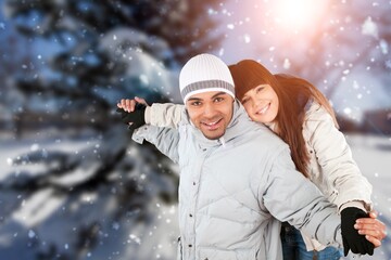 Happy charming pretty marriage couple embracing smiling having fun walking snowy weather outside park