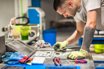 Technician making fridge magnet with soft PVC rubber in mold