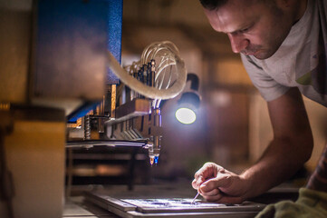 Technician making fridge magnet with soft PVC rubber in mold