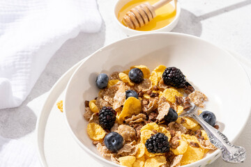 Healthy breakfast concept with oat flakes and fresh berries on white background.