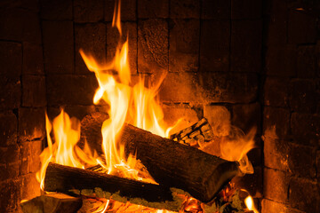 Glowing fire in home stone fireplace