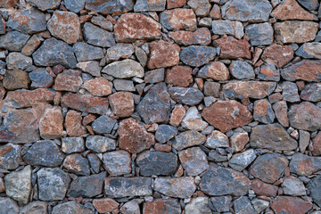 Textured background of masonry wall made of natural stones.