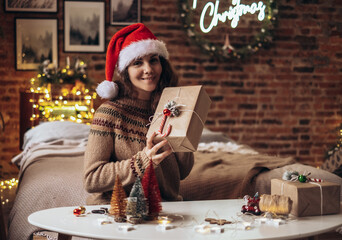 Woman packing Christmas gifts boxes. Unprepared gifts on a white table with decor elements and items Christmas or New Year DIY packaging concept.