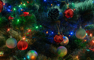 Obraz na płótnie Canvas Multicolored balls on decorated christmas tree close-up with reflection of colored light bulbs garland