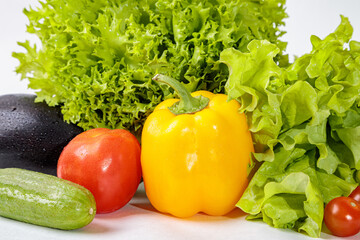 Set of fresh raw vegetables on a white background. Salad, tomatoes, cucumbers, eggplants, zucchini
