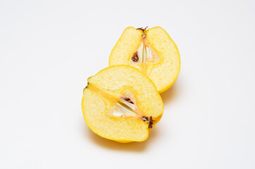 two cut halves of ripe quince on a white background
