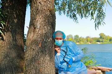 COVID-19 Pandemic Coronavirus. Caucasian male doctor pediatrician in medical facial mask hold...